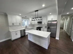 Kitchen renovation with custom cabinetry and large white quartz island
